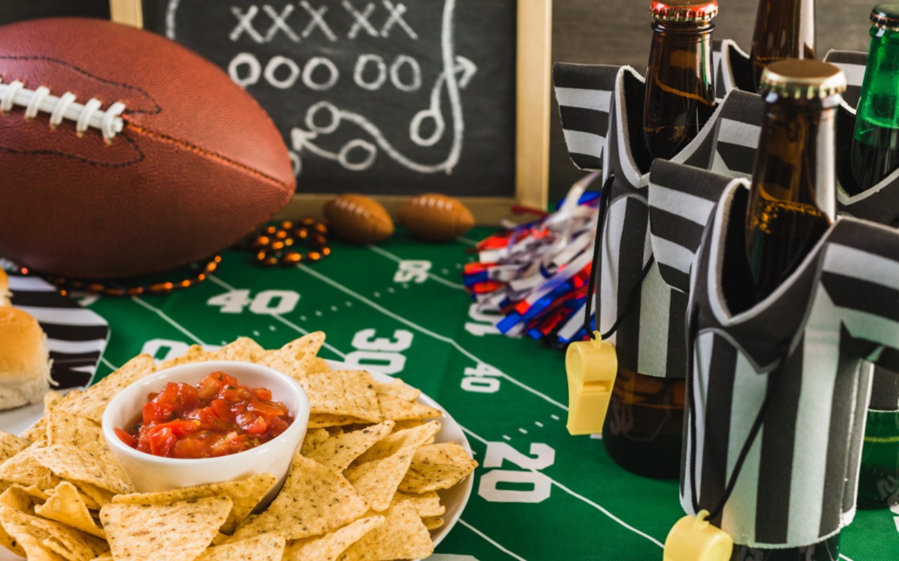 Super Bowl party table with beer, football, chips, and salsa.