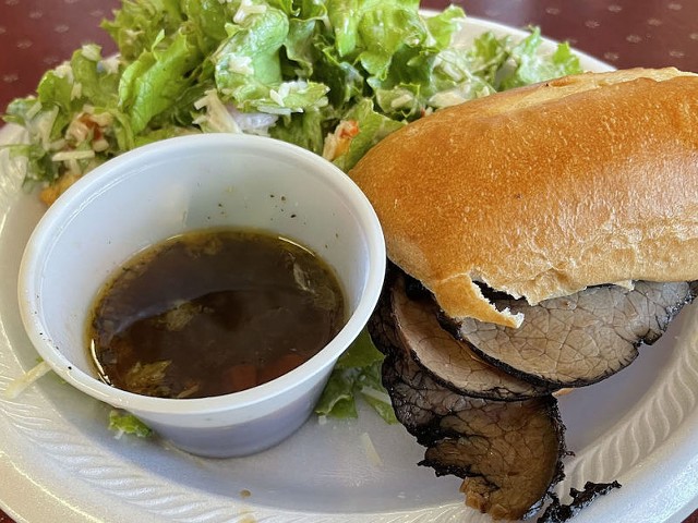 Alley Cat Cafe's version of a classic french dip roast beef sandwich comes sliced on a hoagie roll with a cup of salty bouillon for optional dipping.