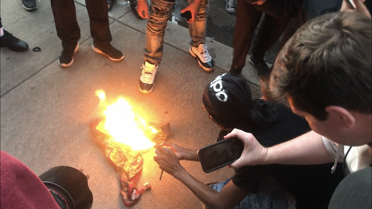 A protester burns a flag downtown.  |  Photo by Danielle Grady.