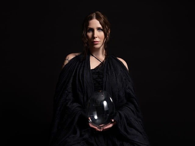 Singer-songwriter Chelsea Wolfe in a voluminous black gown holding a large crystal ball