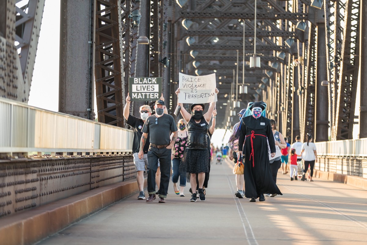 The recent killings of Black people by police, including in Louisville, brought the Derby City Sisters and others to The Big Four Bridge for a vigil to show solidarity. - KATHRYN HARRINGTON