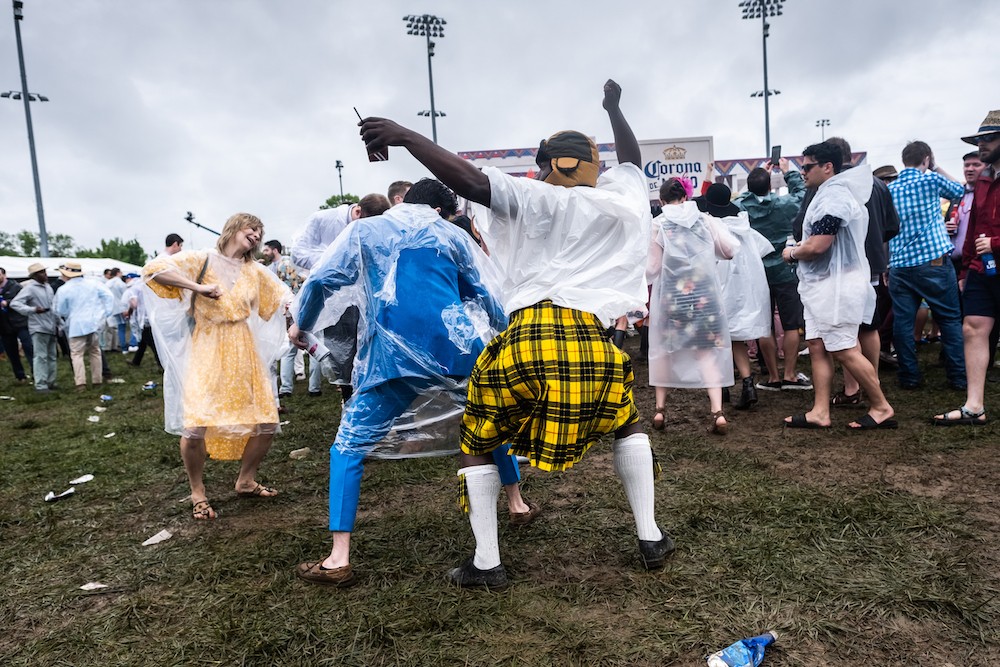 Despite the rain and mud, a group of friends dance in the infield at Churchill Downs.