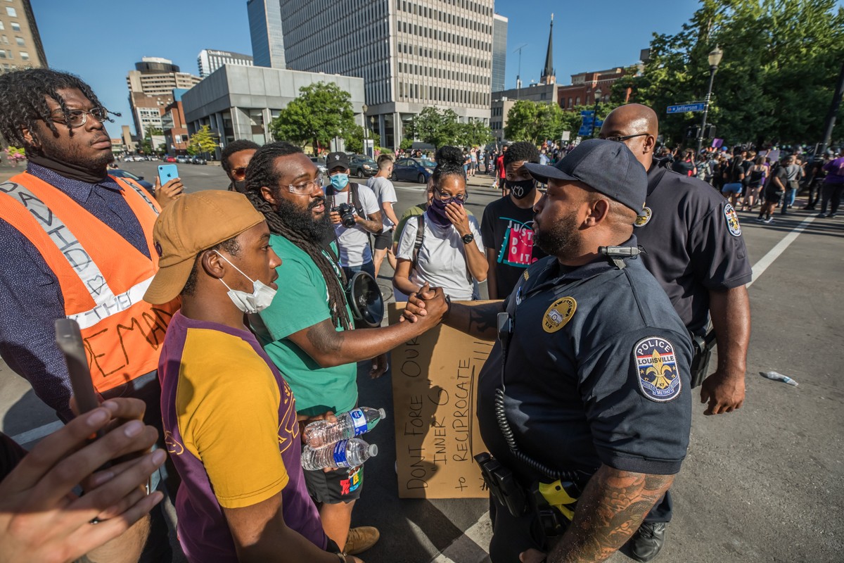 In what appeared to be a deescalation of confrontations in recent days, Louisville police officers came to talk with protesters. - KATHRYN HARRINGTON