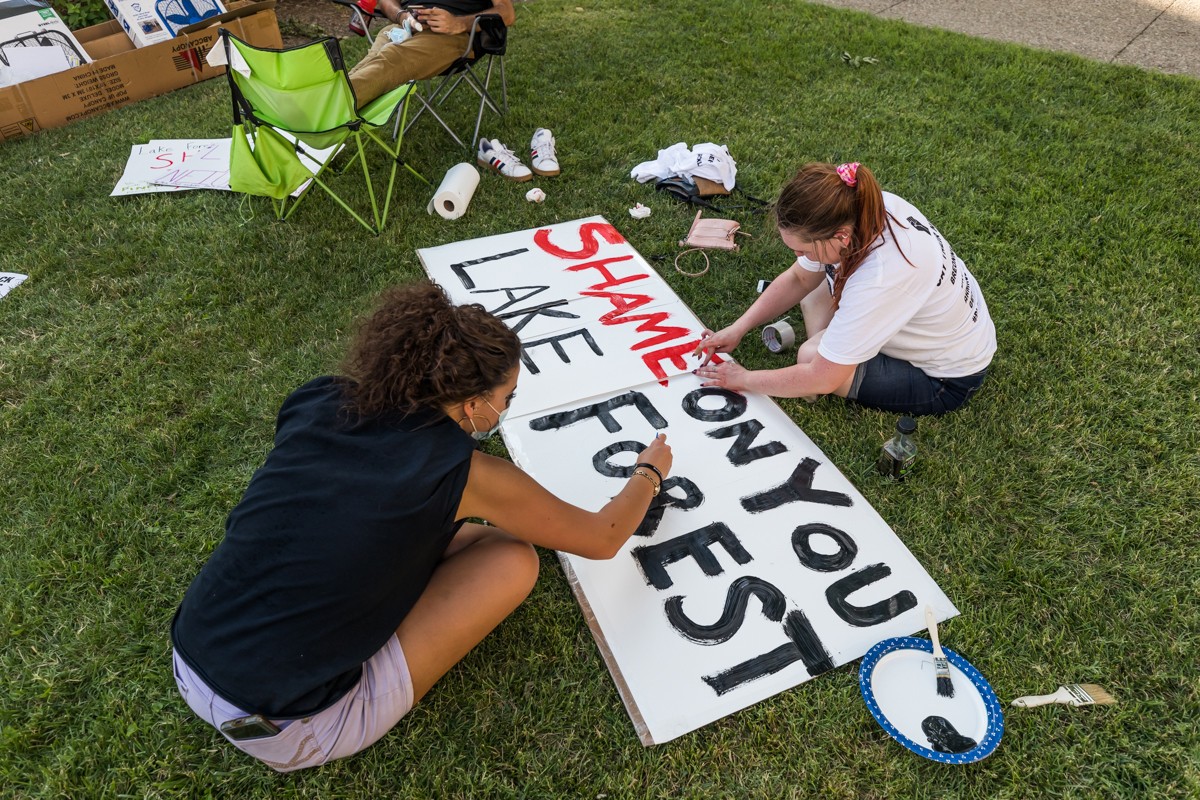 Carson Haynes and Sarah Urda worked on a poster at the Healing and Art Social Justice Festival. This sign references racially motivated vandalism at Lake Forest. - KATHRYN HARRINGTON