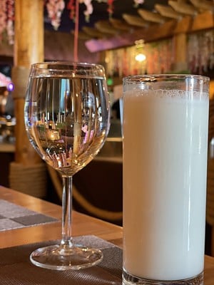 A tall and very salty lassi yogurt drink and a goblet of water, offered without ice, stand ready to cool the fires of spicy Indian fare.