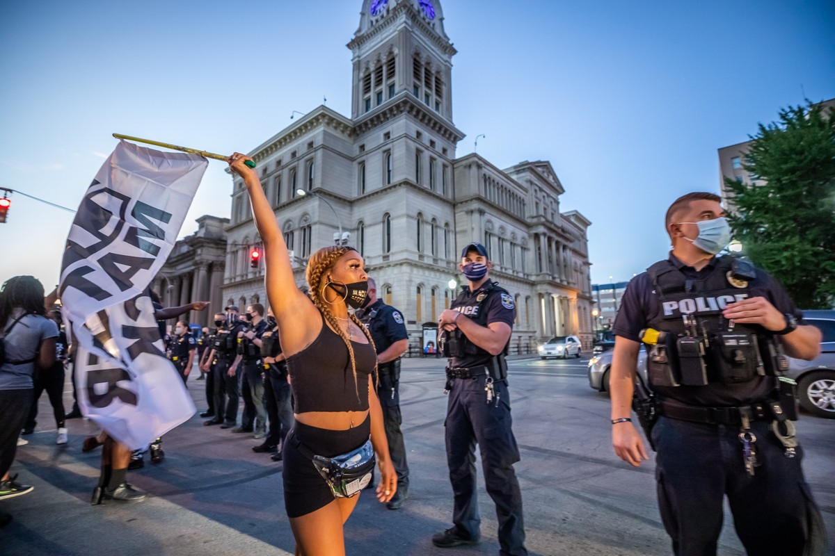 Dynasty Davidson waved a large Black Lives Matter flag as she walked past LMPD officers. - KATHRYN HARRINGTON