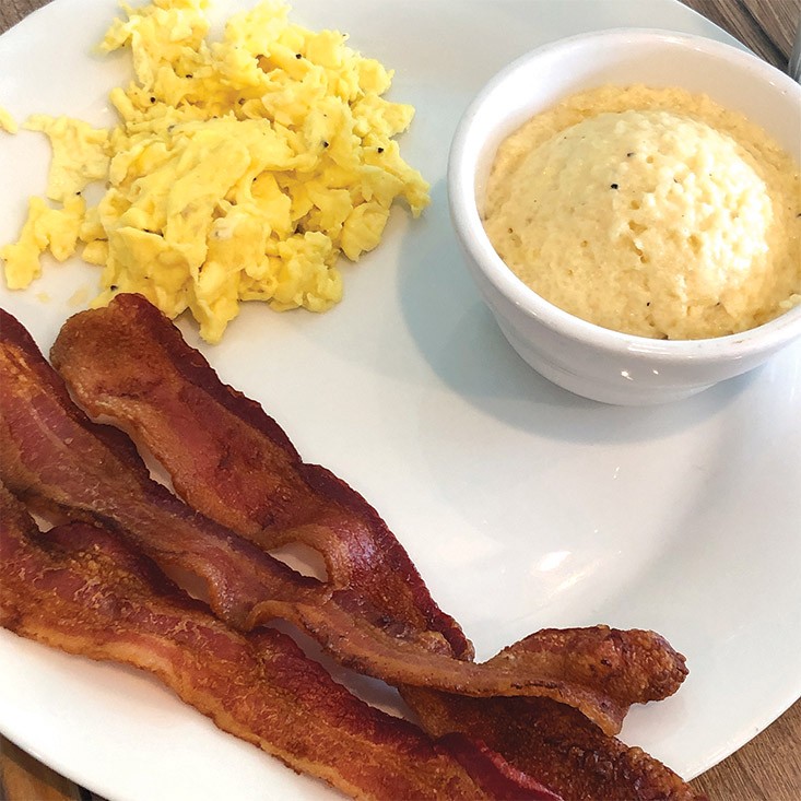 Scrambled eggs, thick bacon and rich cheese grits make a filling breakfast at Gracious Plenty.