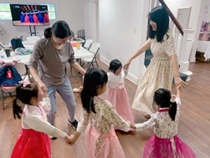 Young students at the Korean School of Louisville dance with their teachers.