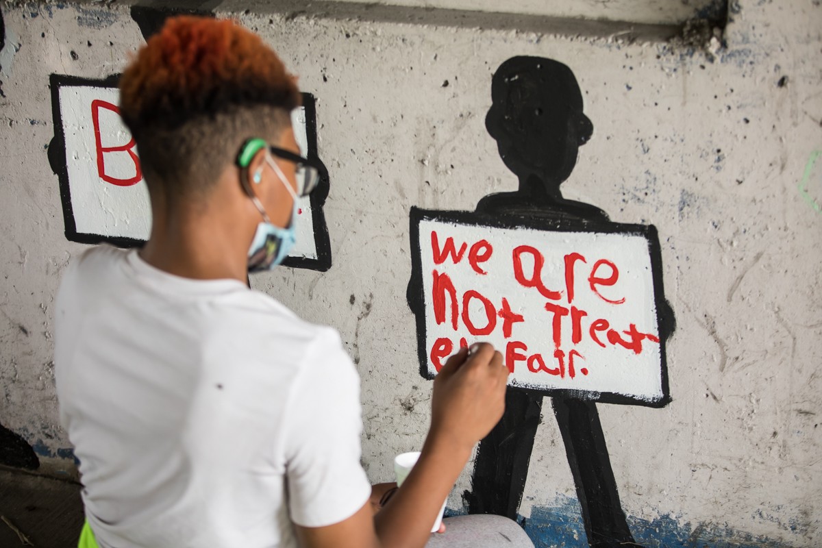 A participant in the event on Saturday painted &#145;We are not treated fair&#146; - on the Take a Knee Bridge on Broadway.  |  Photos by Kathryn Harrington. - KATHRYN HARRINGTON