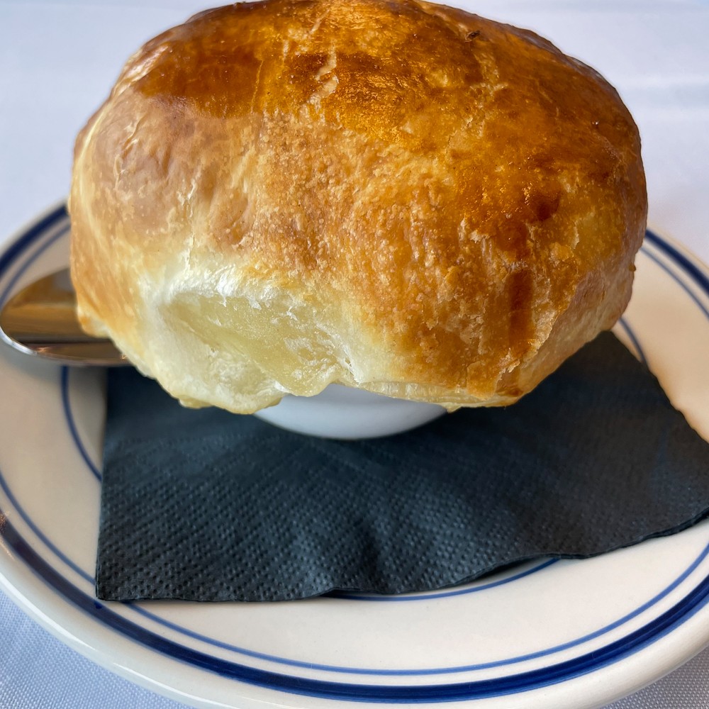A golden dome of puff pastry crowns a riche, creamy cup of tomato bisque, a popular dish at Napa that's held over by popular demand at Osteria.