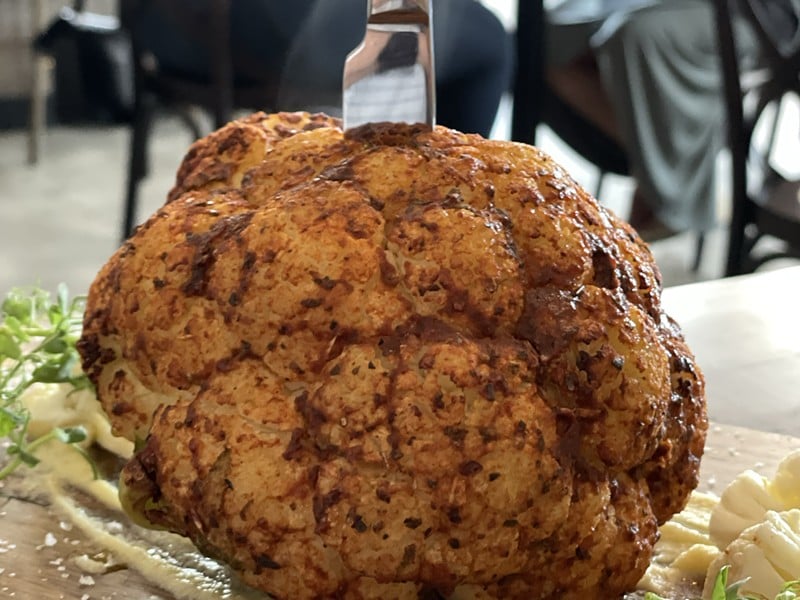 Impressive in its presentation and seductively tasty, a cauliflower entree features three preparations in one: a whole, tender head dusted with spice; quick-pickled florets, and a luscious puree. - Robin Garr